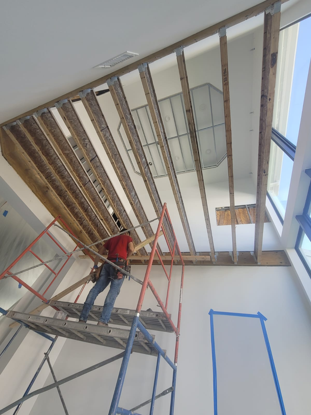 A working on scaffolding inside a house