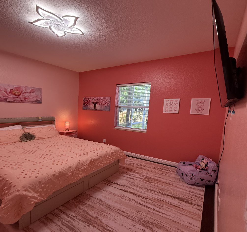 A bedroom with red and pink walls and a wooden floor
