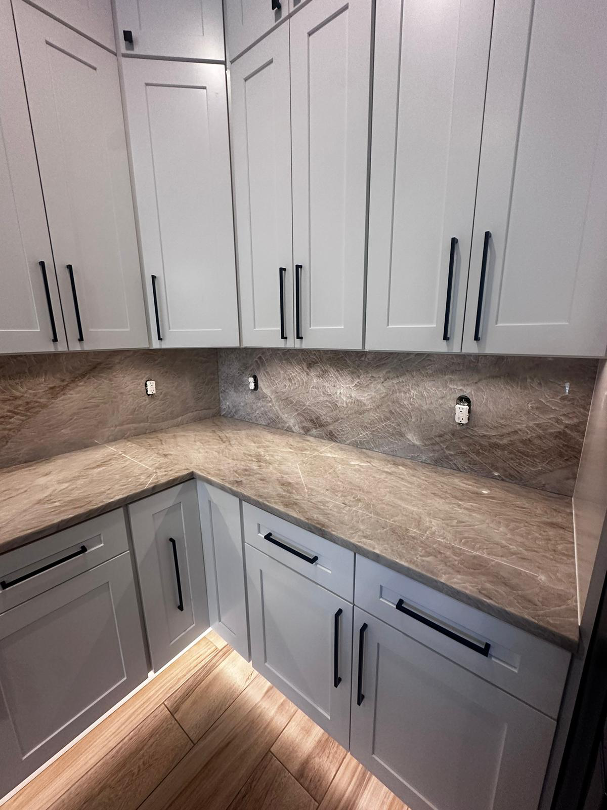 Newly installed white kitchen cabinets during a home remodeling project